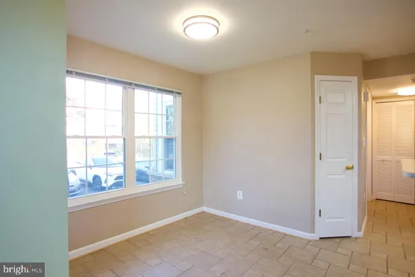 a view of an empty room with a fireplace and a window
