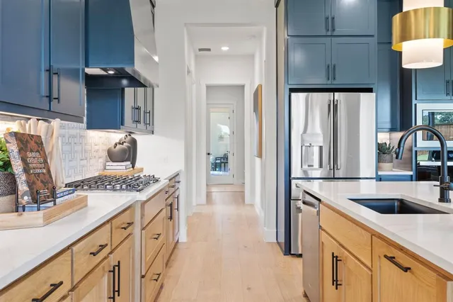 a kitchen with stainless steel appliances granite countertop a sink and a refrigerator