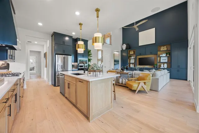 a large white kitchen with a large window and stainless steel appliances