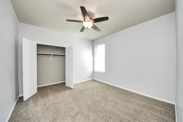 an empty room with closet and windows