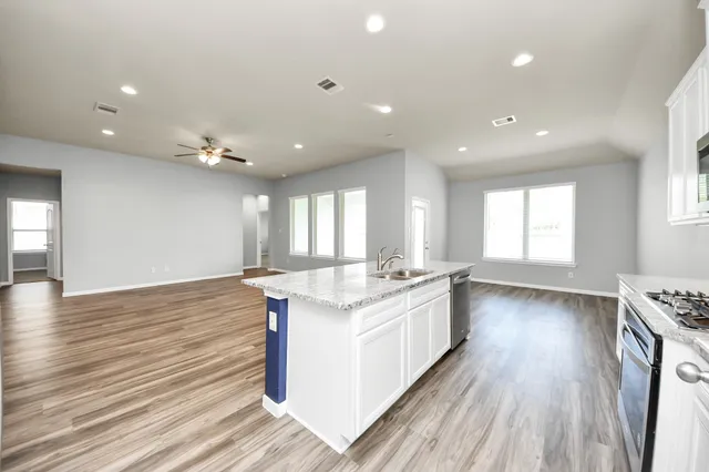 a kitchen with stainless steel appliances granite countertop a stove and wooden floor