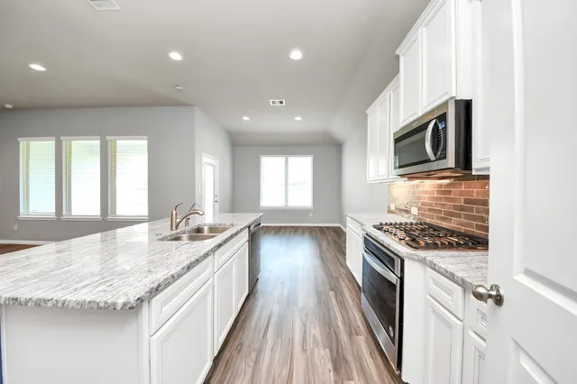 a kitchen with granite countertop a stove and a sink