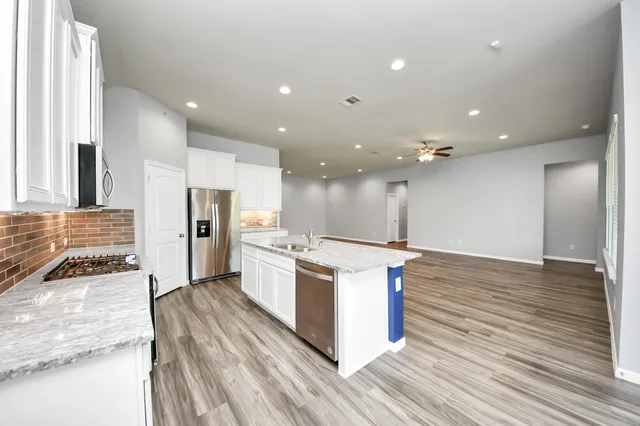 a kitchen with stainless steel appliances granite countertop a stove and a refrigerator