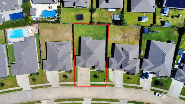 an aerial view of residential houses with outdoor space and parking