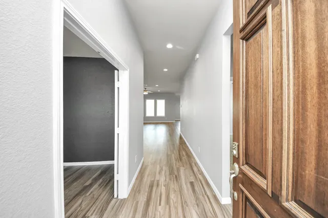a view of a hallway with wooden floor and staircase