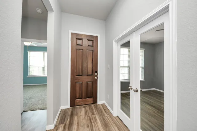 a view of hallway with livingroom and wooden floor
