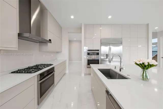 a kitchen with kitchen island a counter top space a stove a sink and cabinets