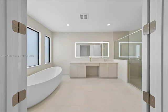 a bathroom with a double vanity sink tub and mirror