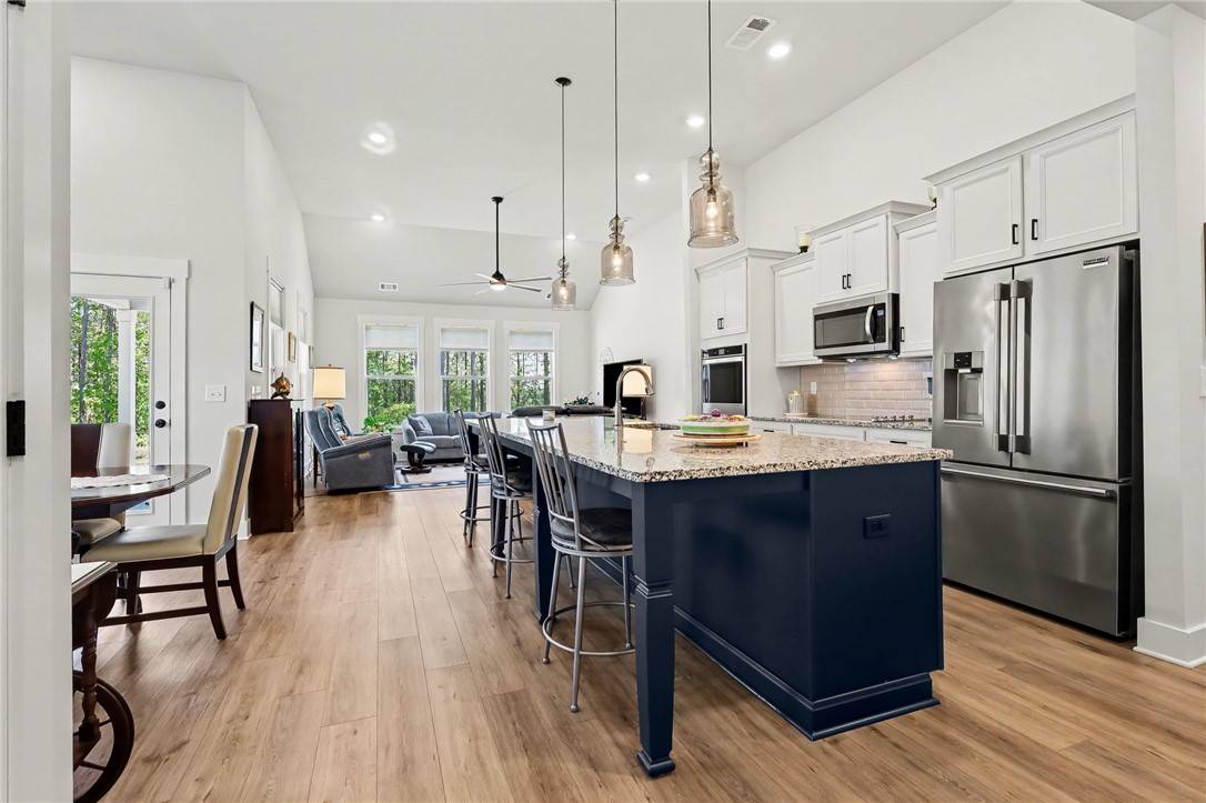 133 Ridgeline Row Central, SC 29630 - Photo 4 of 29 This open-concept kitchen seamlessly flows into the living area, featuring an island with seating.
