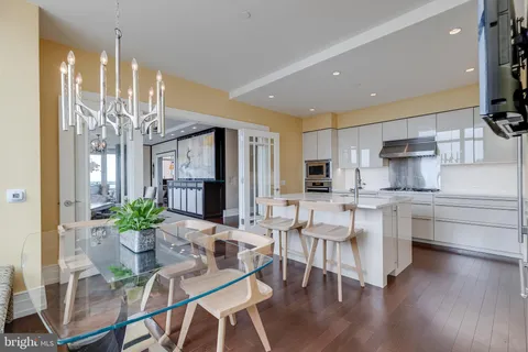 a dining room with furniture a kitchen and chandelier