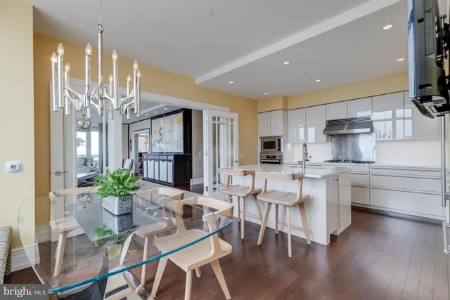 a dining room with furniture a kitchen and chandelier
