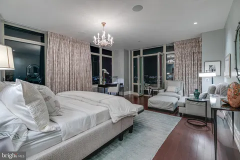 a spacious bedroom with bed and a chandelier