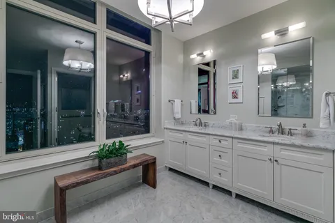 a spacious bathroom with a granite countertop sink a mirror and a shower