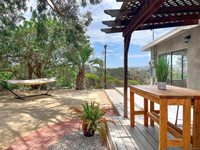 a view of a patio with table and chairs potted plants with wooden floor and fence