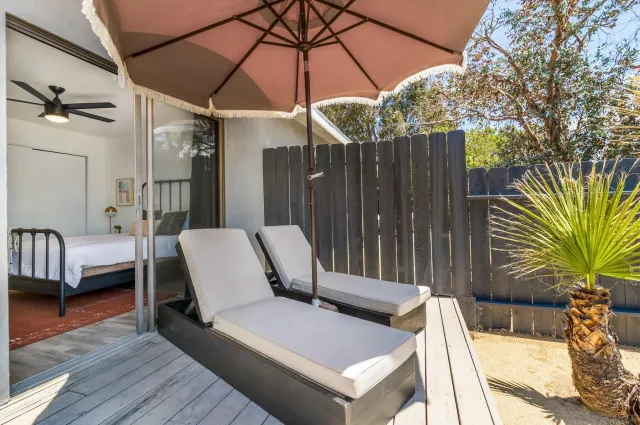 a view of a patio with table and chairs potted plants and floor to ceiling window