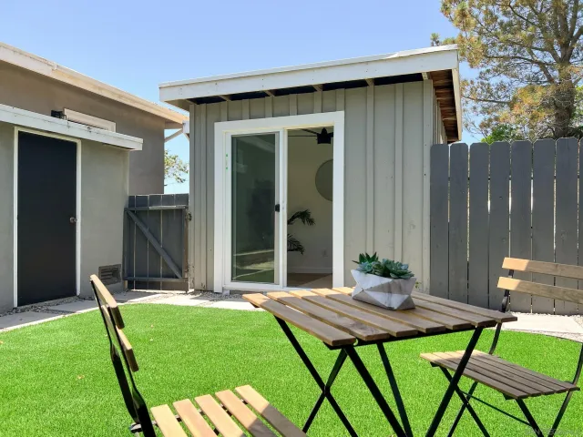 a view of a roof deck with couches and wooden fence