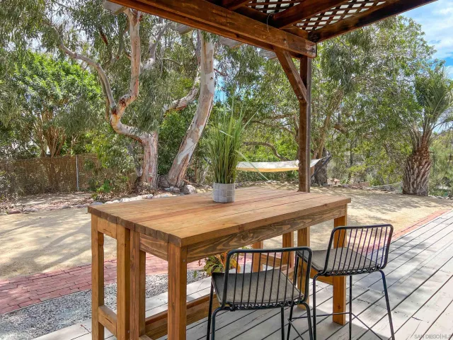 a view of a backyard with table and chairs and wooden fence