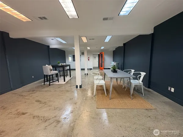a living room with a dining table a table and chairs