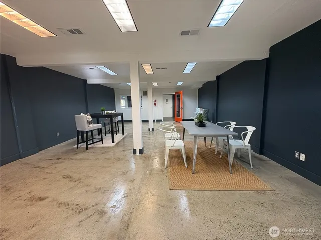 a living room with a dining table a table and chairs