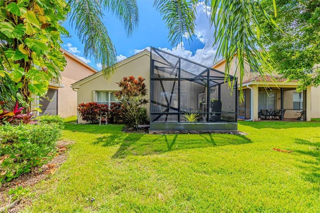 1630 Triangle Palm Terrace Naples, FL 34119 - Photo 20 of 24 a view of a house with pool and a yard