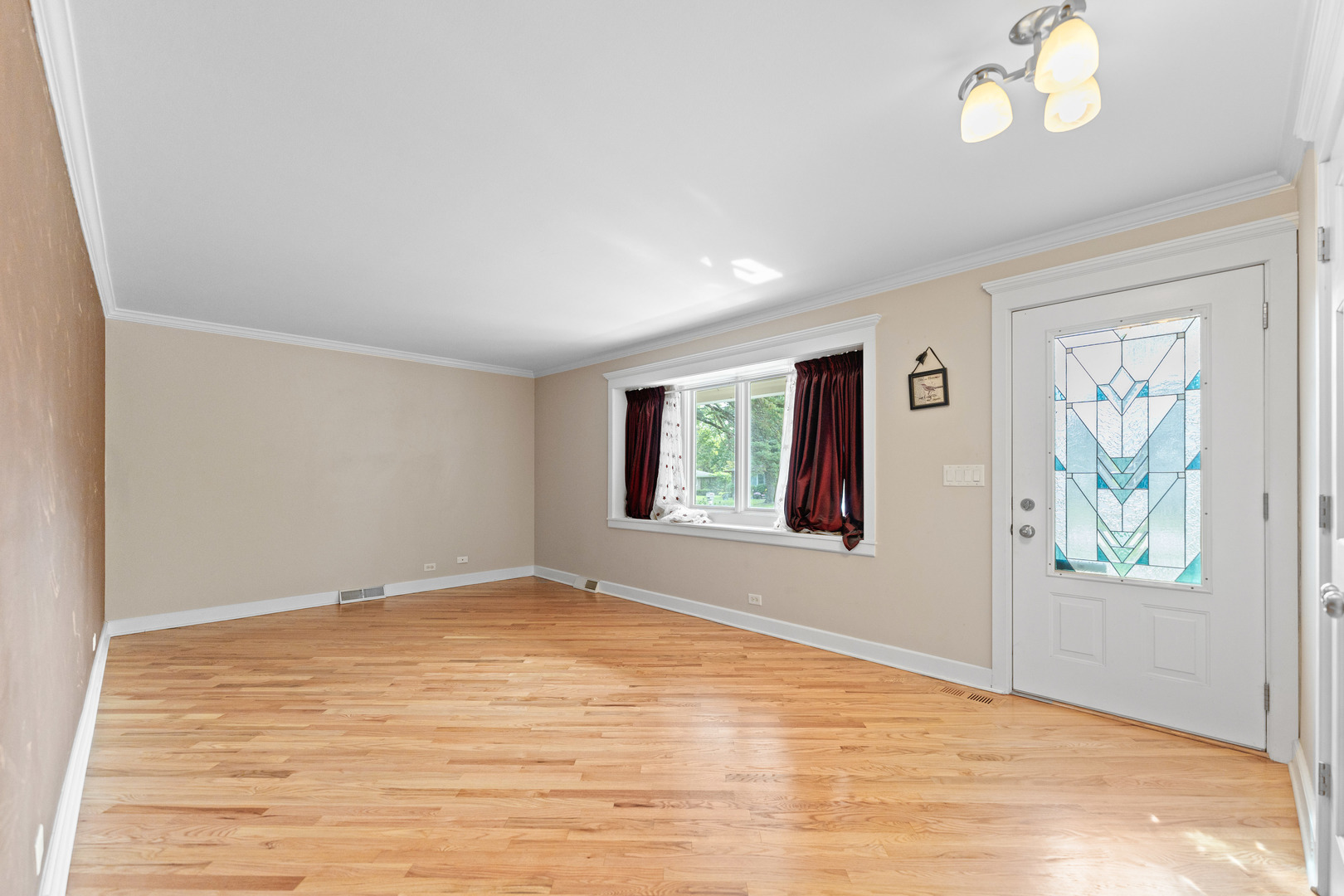 23W620 Walnut Street Roselle, IL 60172 - Photo 4 of 71 a view of an empty room with a window and wooden floor