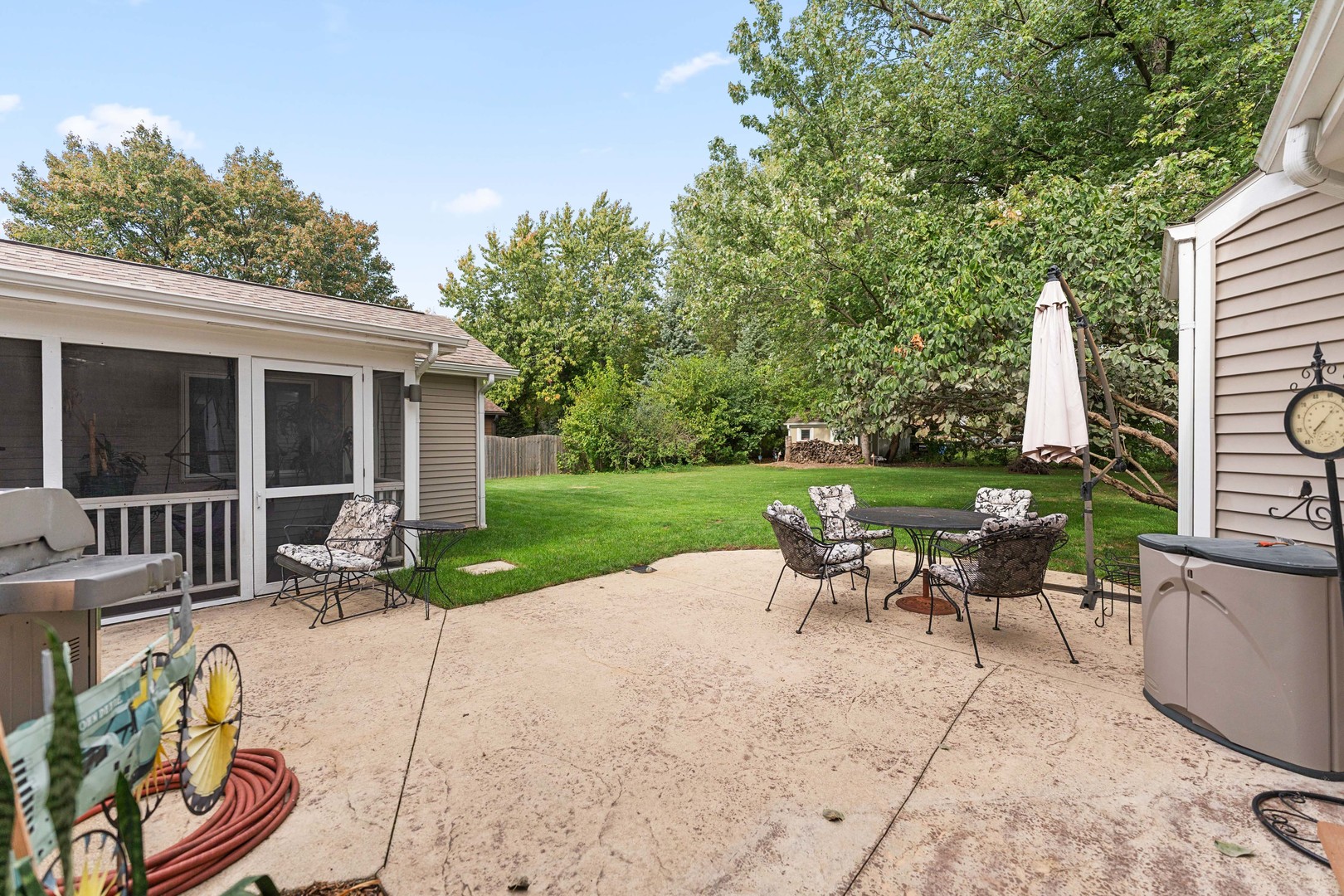 23W620 Walnut Street Roselle, IL 60172 - Photo 53 of 71 a view of a patio with table and chairs potted plants and a palm tree