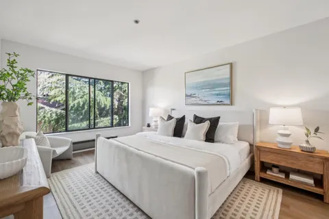 a bedroom with a bed and a large window