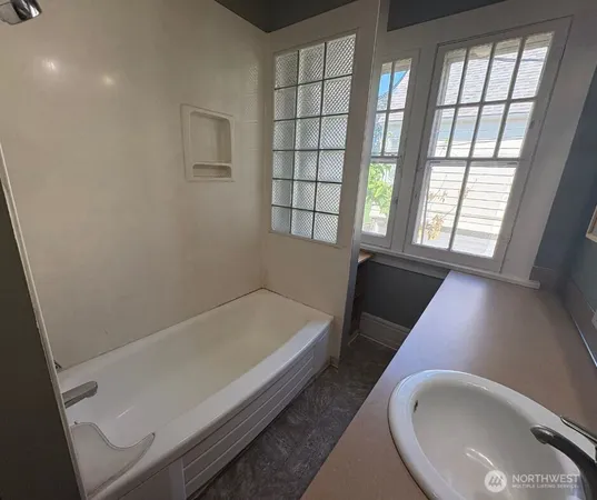 a bathroom with a bathtub and a window