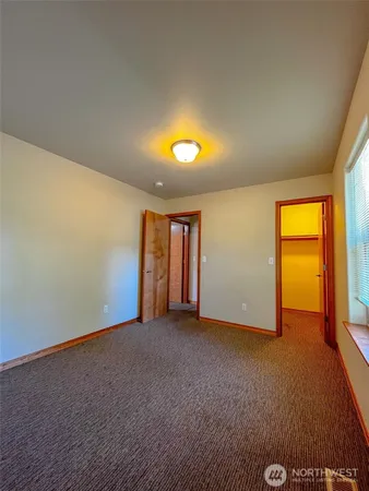 an empty room with a window and fireplace