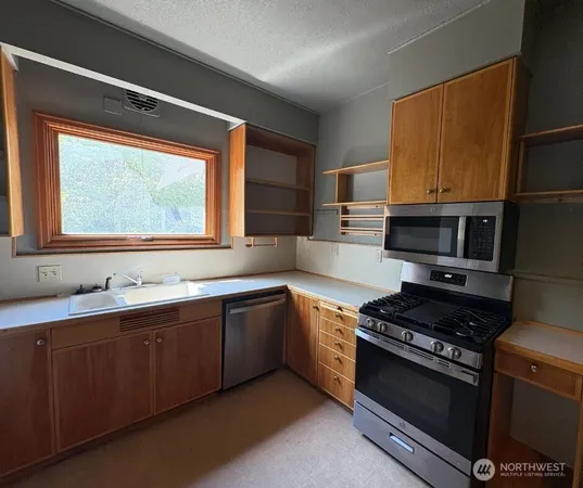 a kitchen with stainless steel appliances a sink stove and cabinets