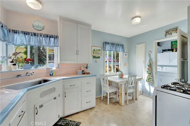 a kitchen with stainless steel appliances granite countertop a stove a refrigerator and a dining table with wooden floor