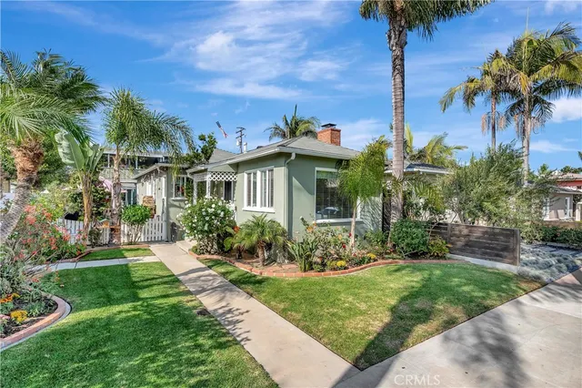 a view of a house with a yard and potted plants