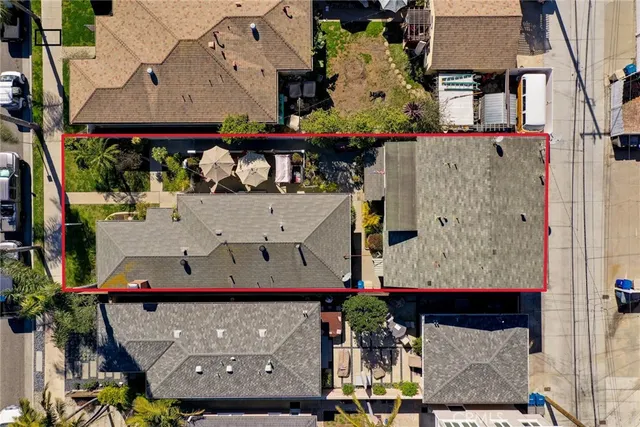 an aerial view of a house with a yard and a large tree