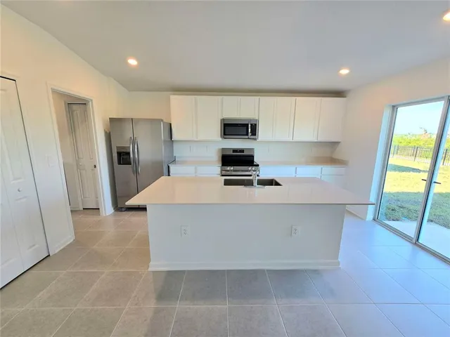 a large kitchen with stainless steel appliances a refrigerator and a stove top oven