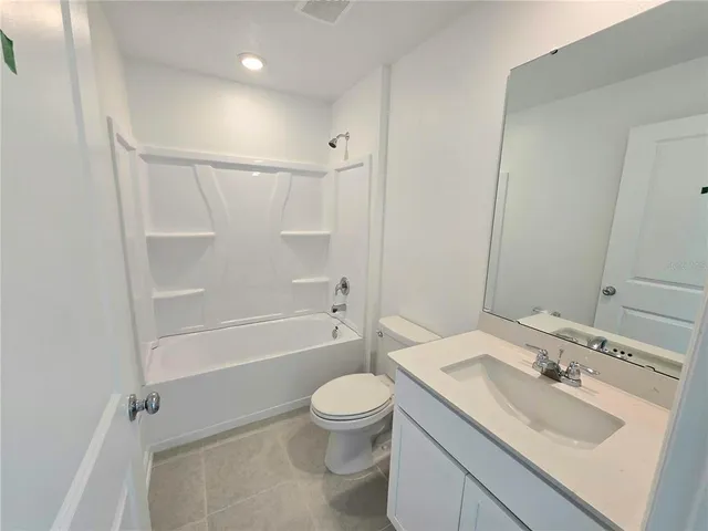 a bathroom with a granite countertop sink a toilet and shower