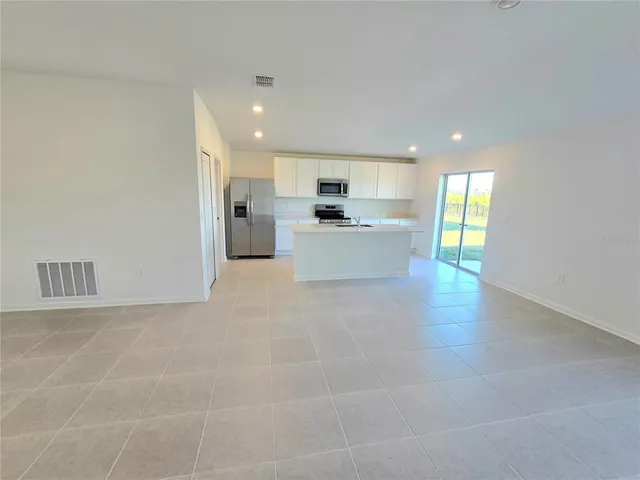a open kitchen with white cabinets and white appliances
