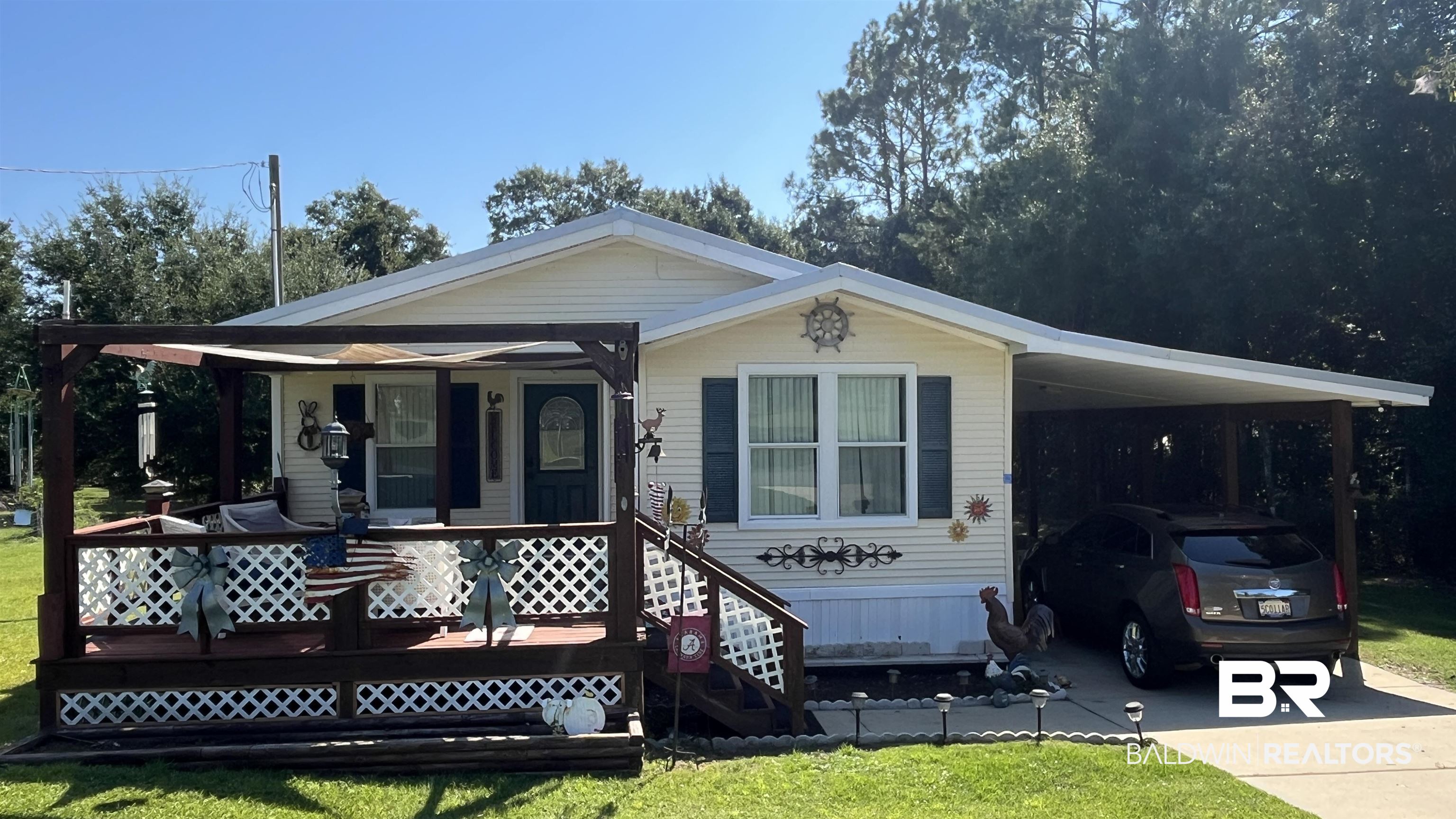 12932 Santa Piedro Street Lillian, AL 36549 - Photo 1 of 20 View of front of property with a porch, a front yard, driveway, and an attached carport