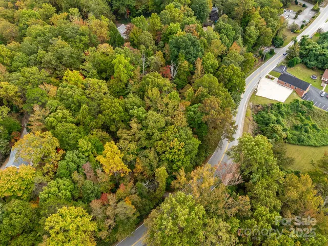 an aerial view of residential houses with outdoor space and trees
