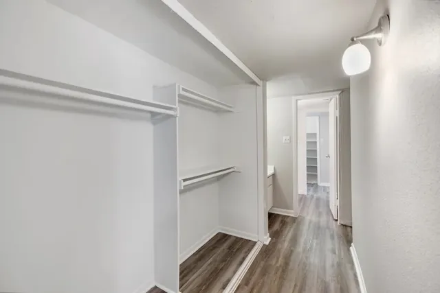 a view of walk in closet with wooden floor
