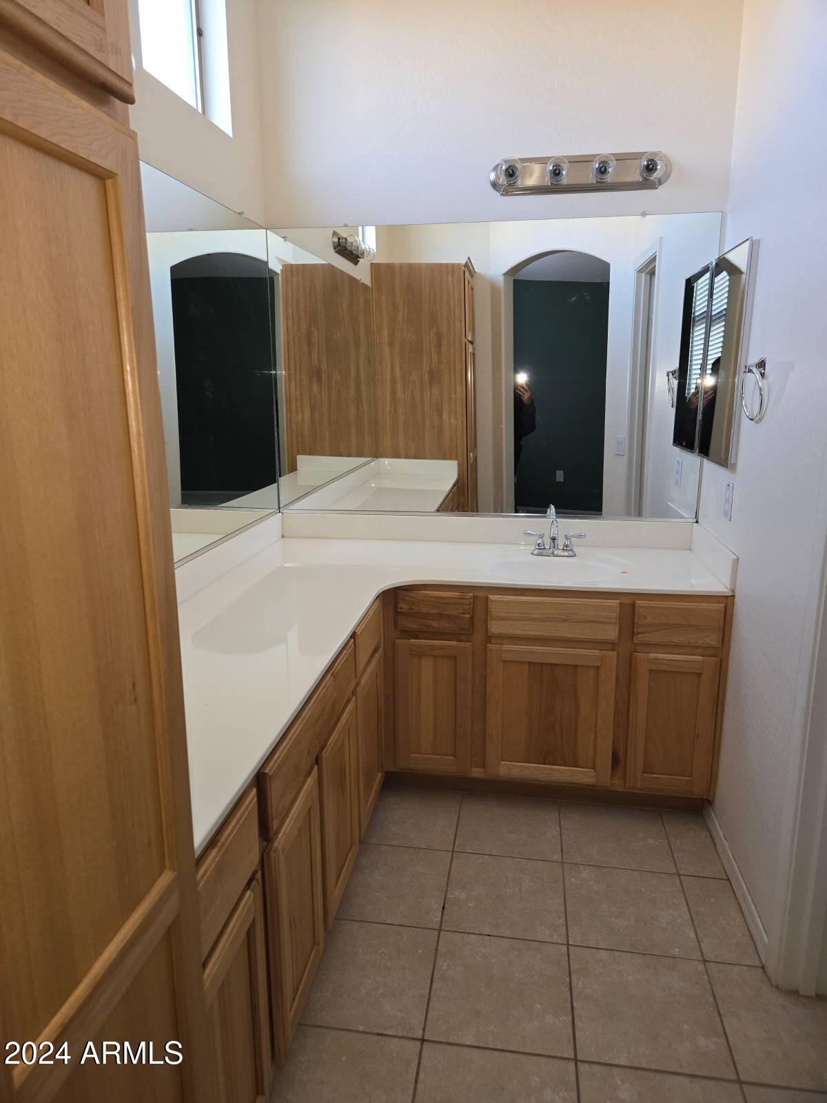 17365 North Cave Creek Road, Unit 114 Phoenix, AZ 85032 - Photo 12 of 18 a bathroom with a sink a vanity and mirror