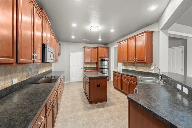 a large kitchen with stainless steel appliances granite countertop granite counter tops and a large window