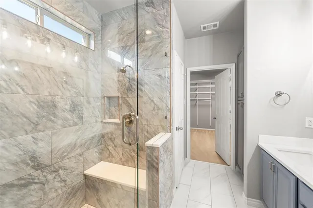 a bathroom with a granite countertop sink a toilet and shower