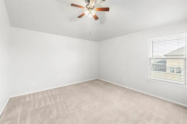 an empty room with a window and a ceiling fan
