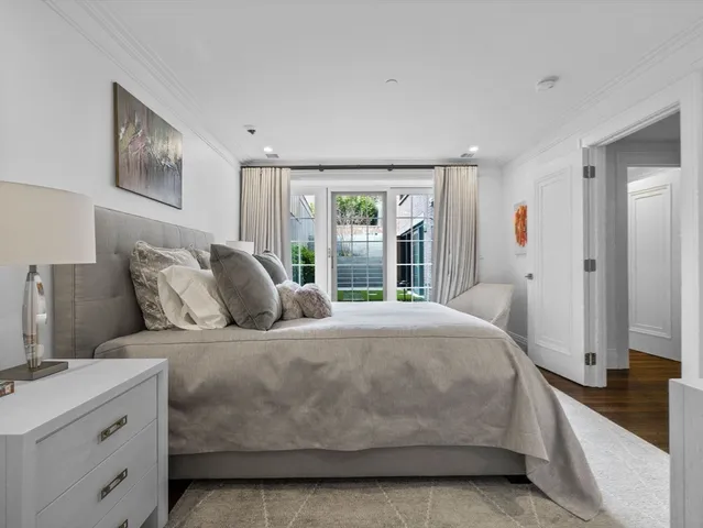 a bedroom with a large bed and a flat tv screen on dresser