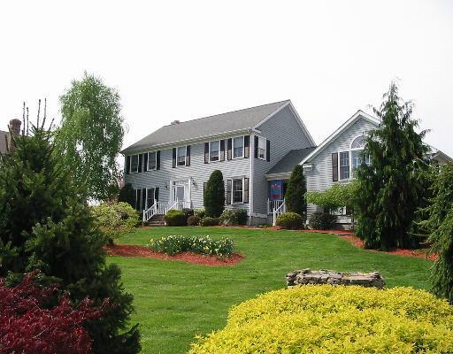a front view of a house with a garden and plants
