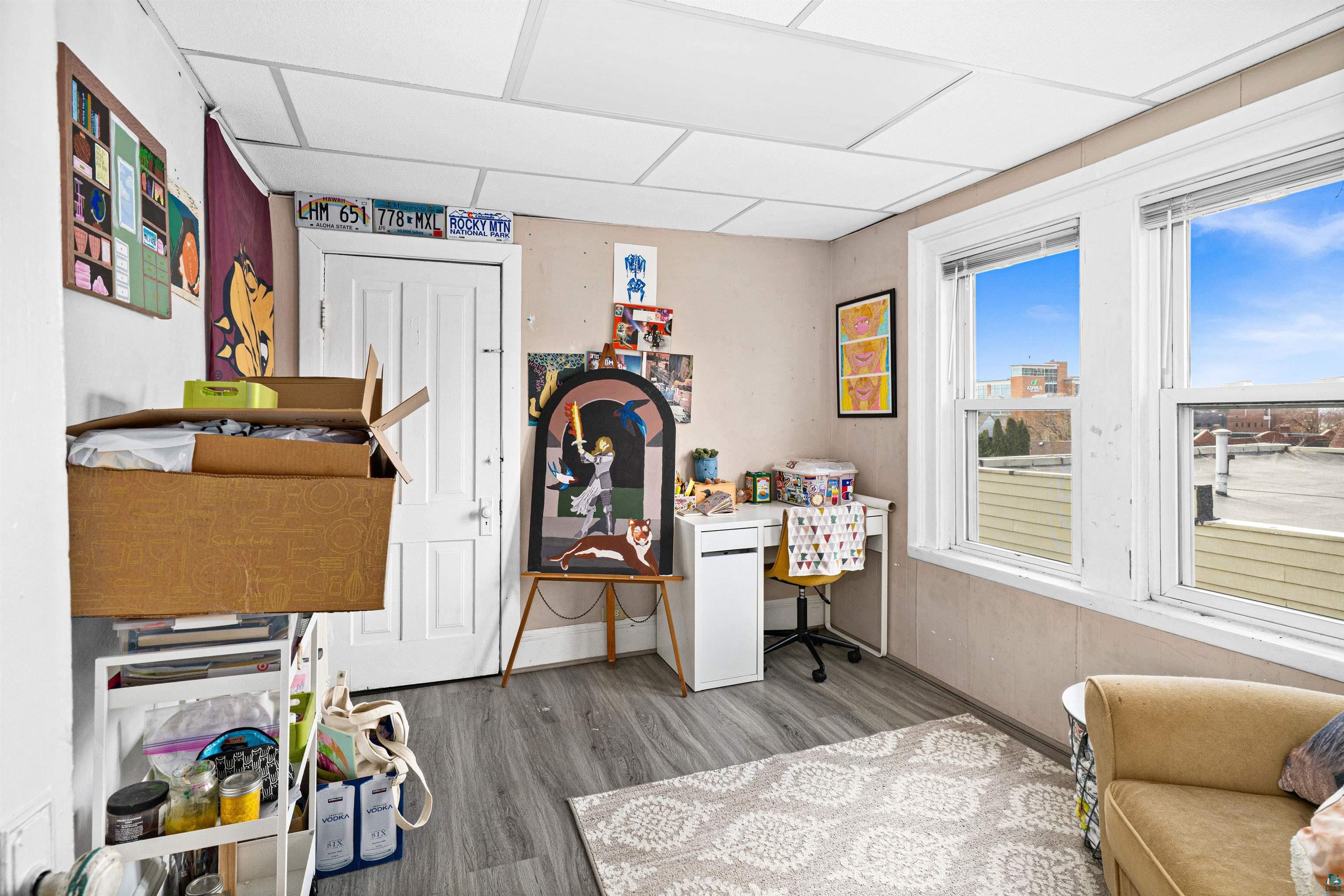 1127 East 3rd Street Duluth, MN 55805 - Photo 14 of 28 Bright room featuring two large windows, wood-finish flooring, and a drop ceiling