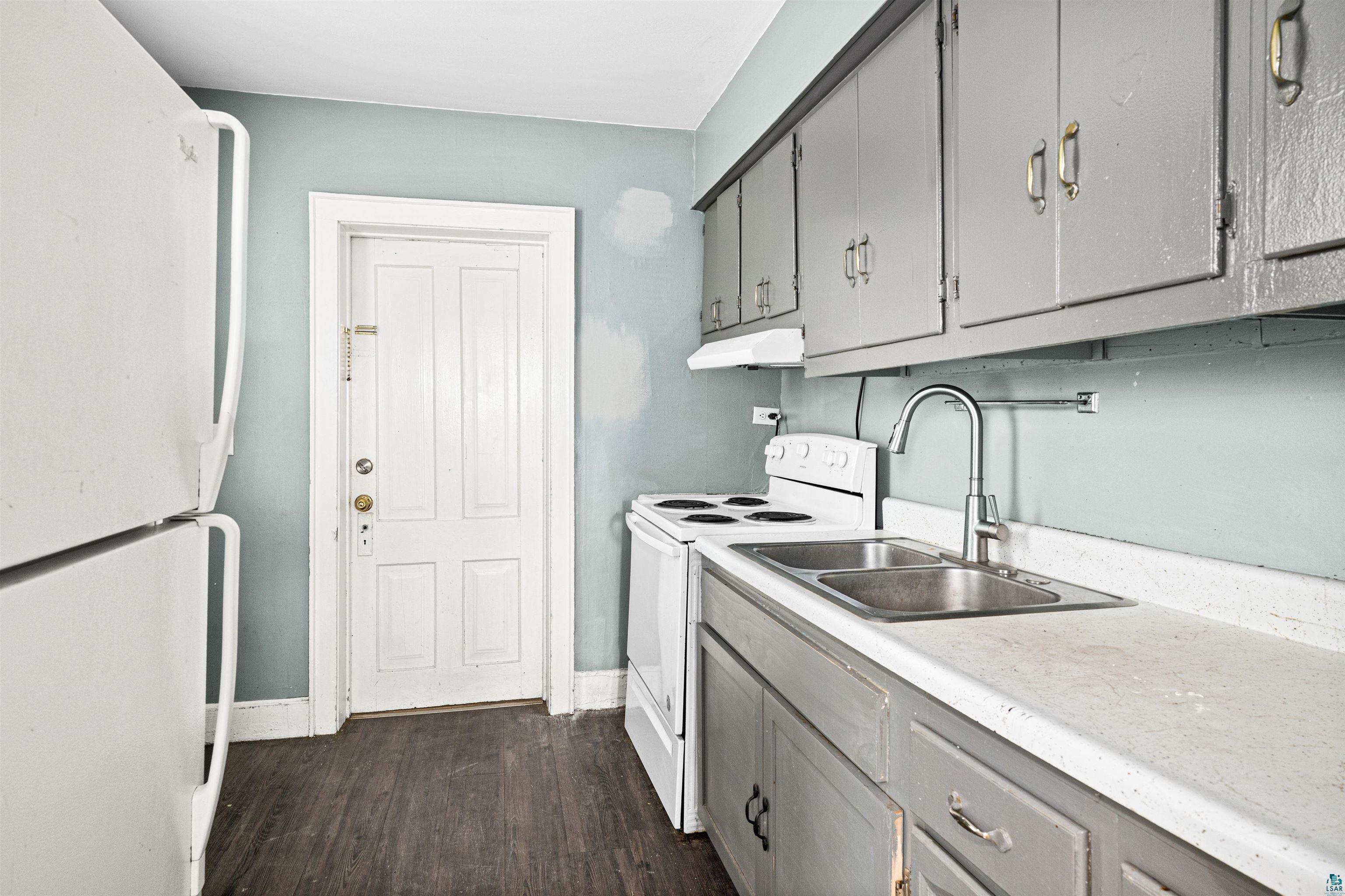 1127 East 3rd Street Duluth, MN 55805 - Photo 5 of 28 Kitchen featuring wood-finish flooring, light blue walls, and a white paneled door
