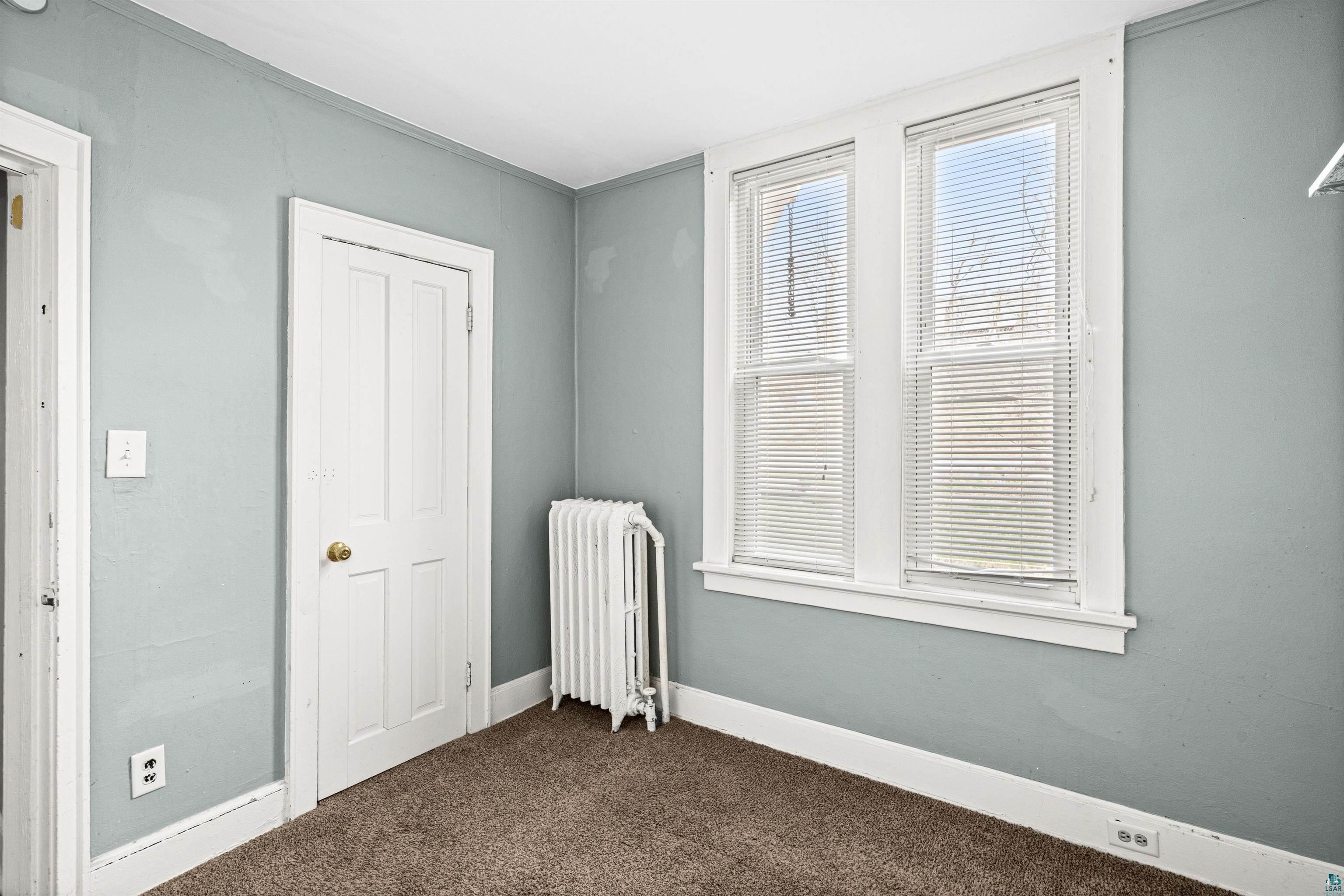 1127 East 3rd Street Duluth, MN 55805 - Photo 7 of 28 Room with light blue walls, brown carpeting, and white trim