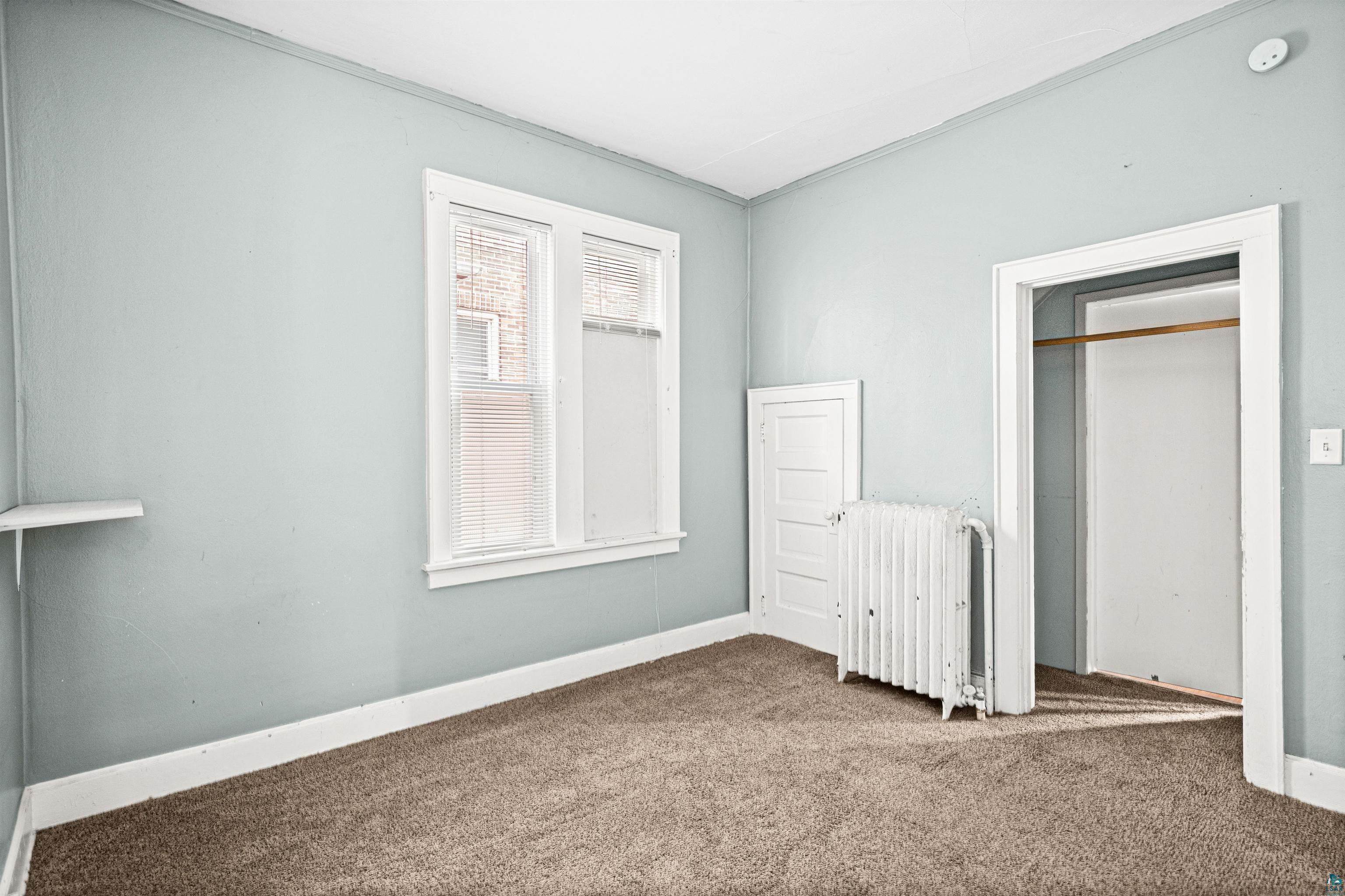 1127 East 3rd Street Duluth, MN 55805 - Photo 8 of 28 Room featuring light blue walls, brown carpeting, and white trim