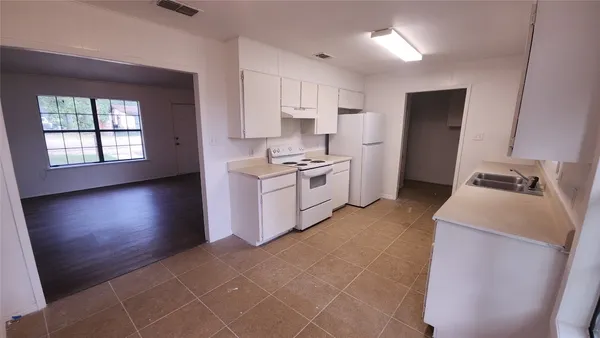 a kitchen with a sink a stove a refrigerator and a window